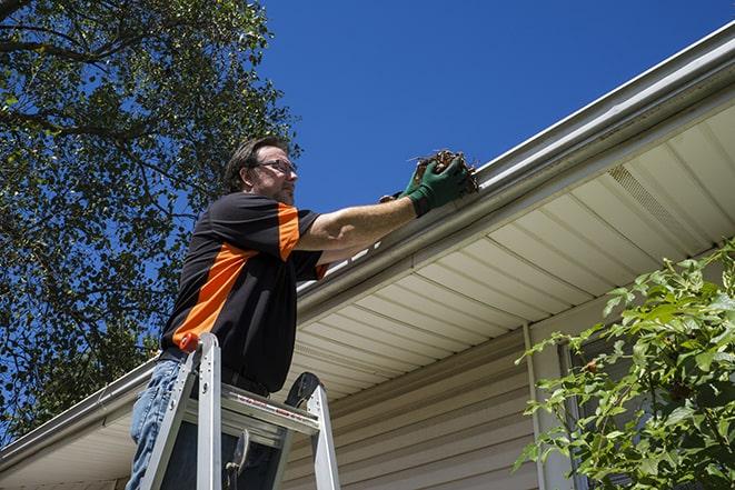 skilled laborer conducting repairs on a house's gutter in Beverly Shores